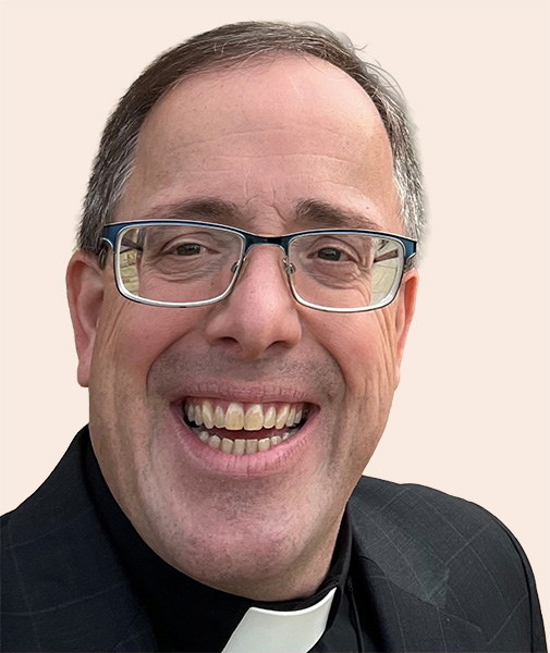 Jude A Urso GC_nobackground Smiling man with short hair and glasses.