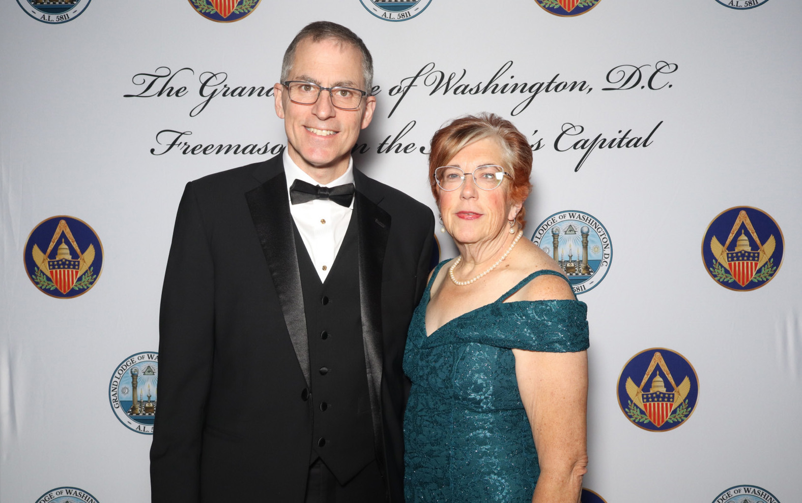 Smiling man and woman in formal attire.