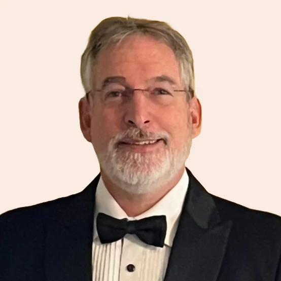 Smiling man with glasses and short hair in suit and bow tie.