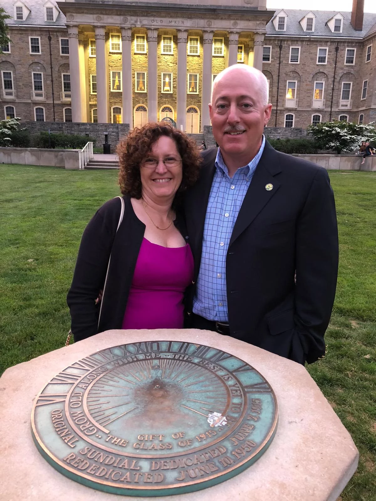 Grand Master Robert Brink and his wife standing in front of sun dial outdoors at Penn State University.
