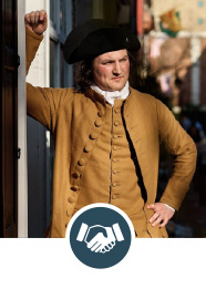 Man dressed in Revolutionary War costume leaning against wall with hand shaking icon.