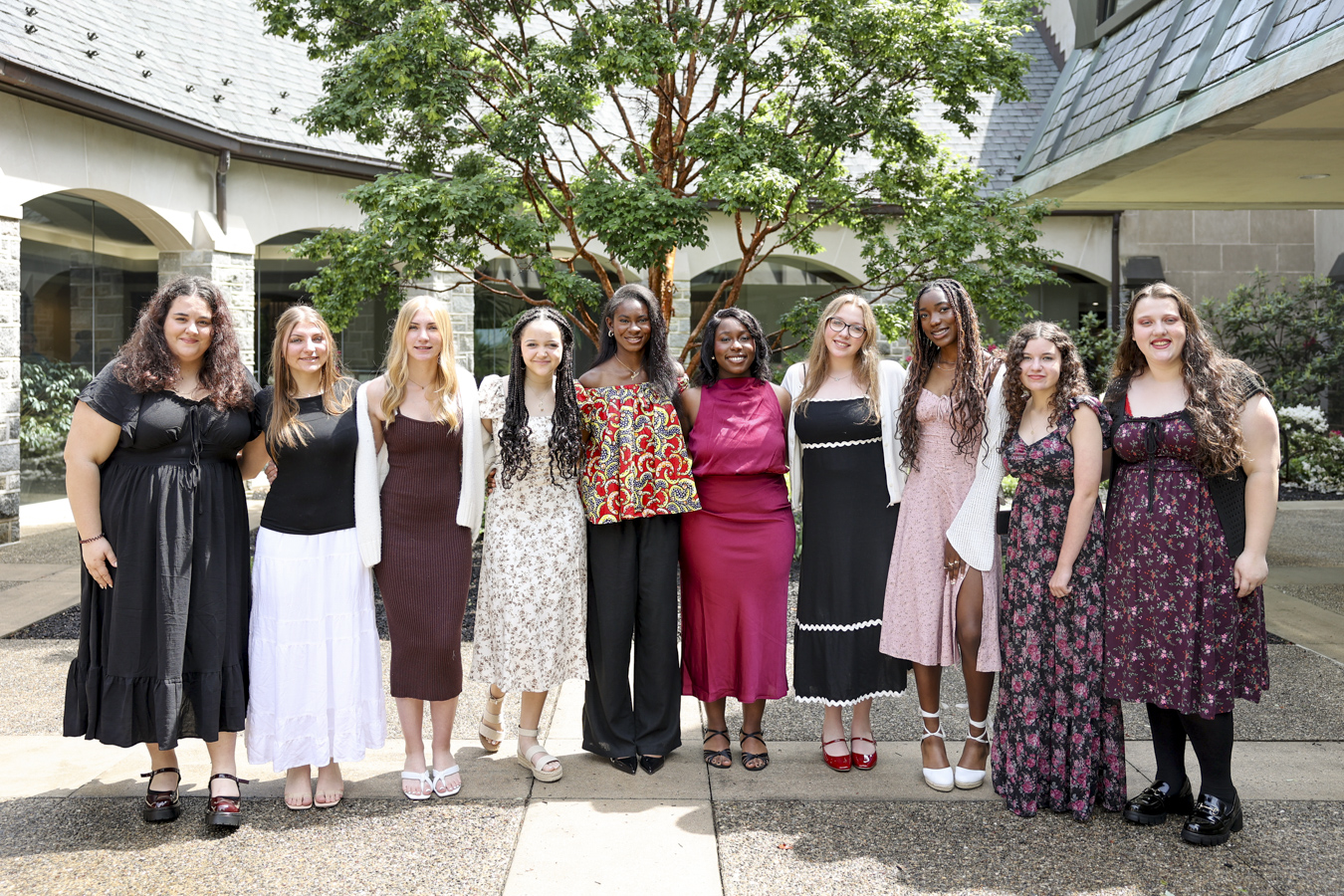 Smiling group of teen girls dressed up for Youth Appreciation Day standing outdoors.