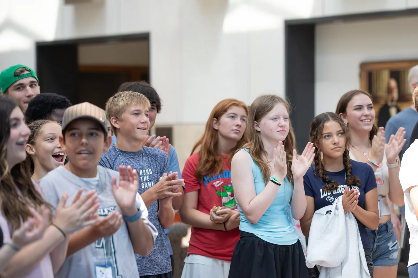 Group of children smiling and clapping.
