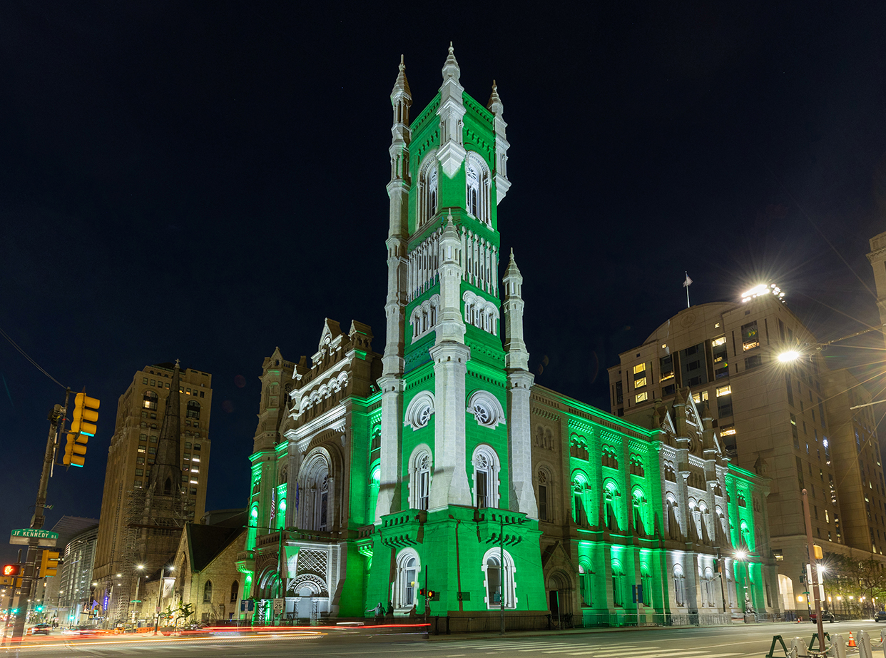 The Masonic Temple, Library and Museum illuminated at night with green and white lights.
