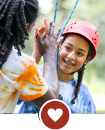 Teenage girl and boy high fiving, the girl is wearing climbing gear, a heart icon is at the bottom of the image.