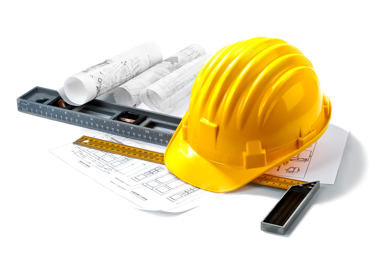 Closeup of construction helmet laying on top of tools and floor plans.