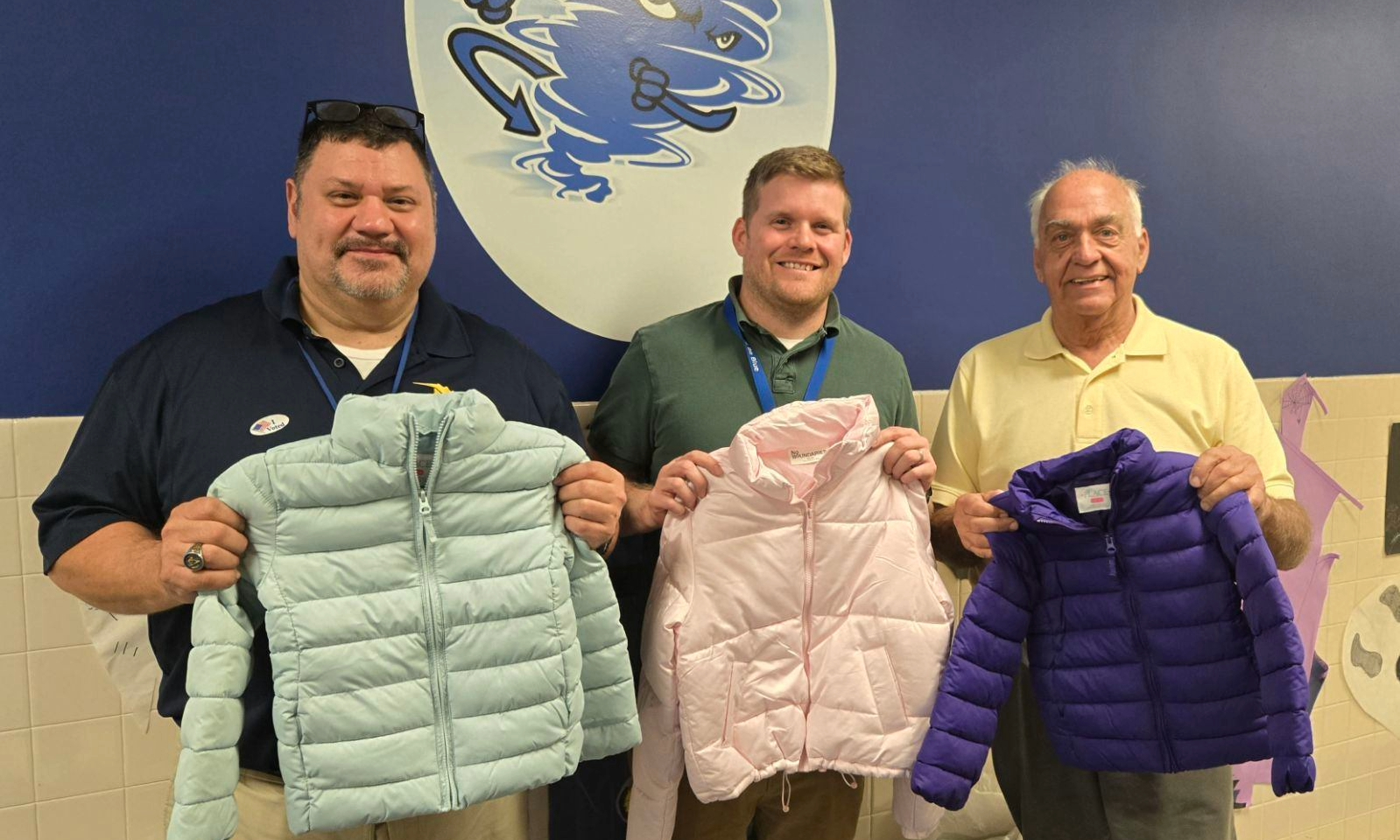 image000000 (1) (1) Smiling men holding up coats.