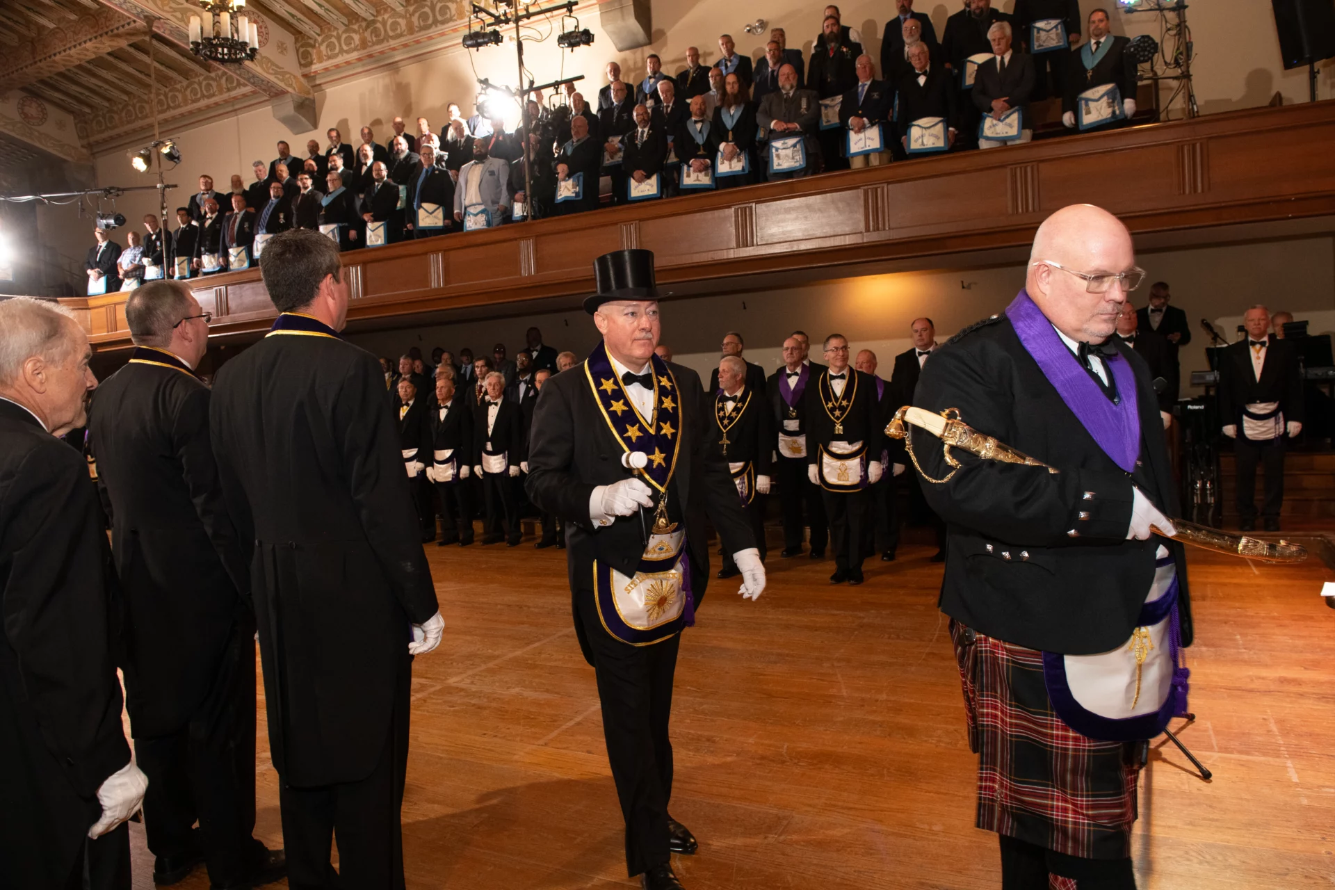 Grand Master Robert Brink walking through standing group of Masons.