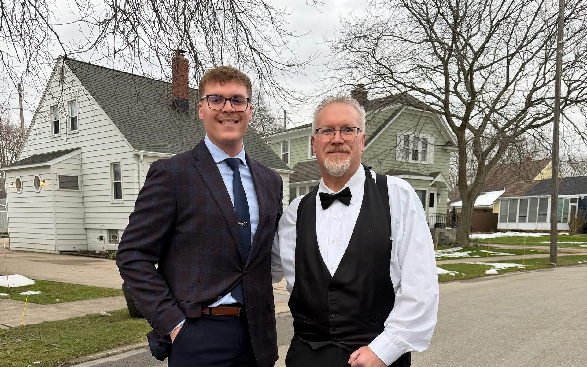 Smiling father and son standing together in a neighborhood.