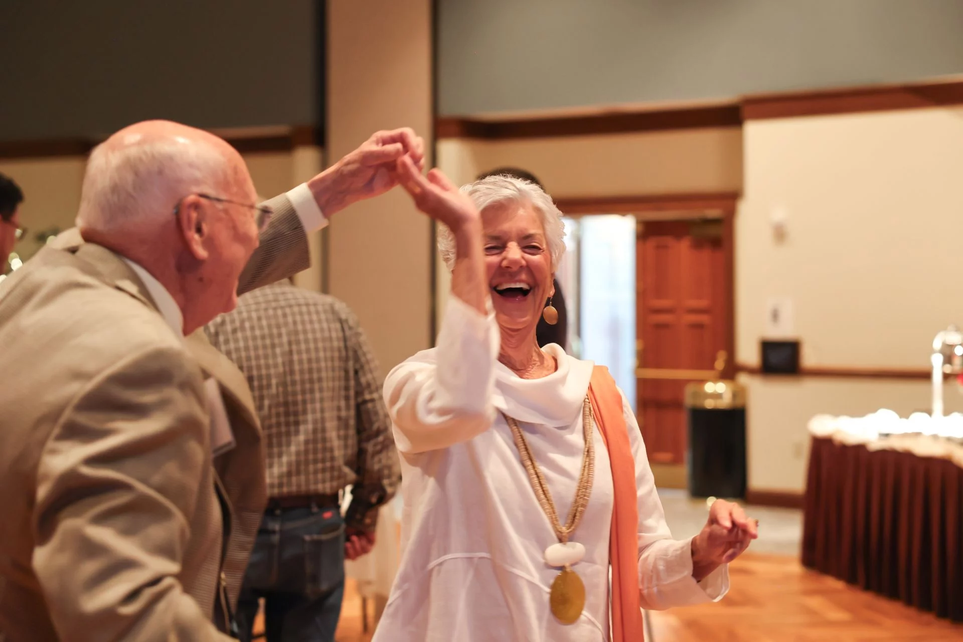 1W8A7231 Smiling senior couple dancing in a banquet.