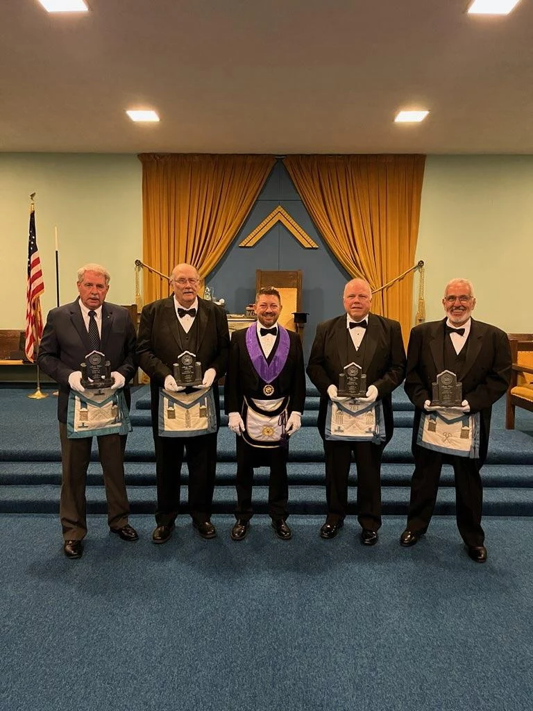 9914da5a-cce8-4a3b-a315-11fd0febed5c Smiling group of men standing in a lodge room together.