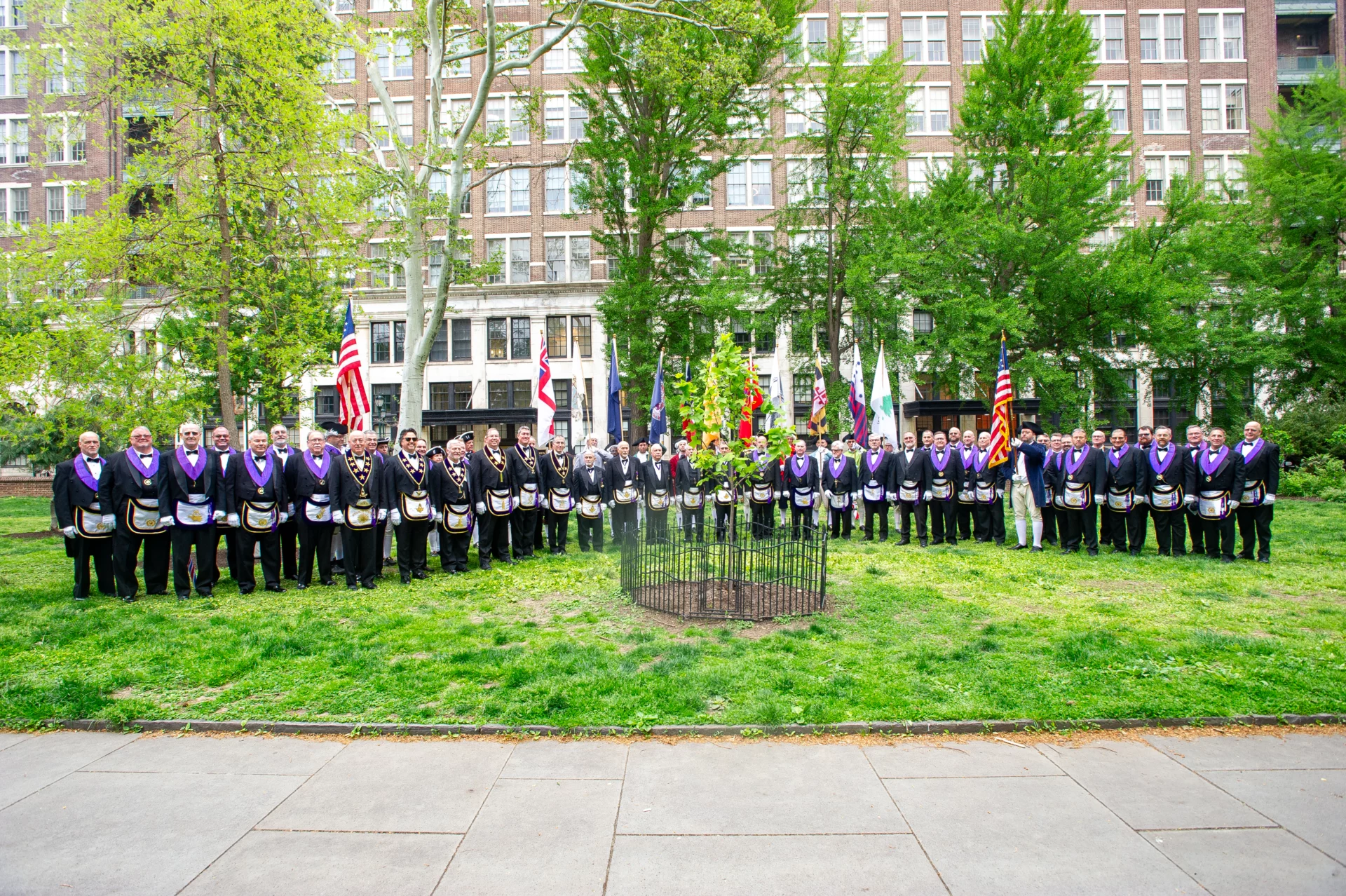 Large group of Masons standing around newly planted Liberty Tree.