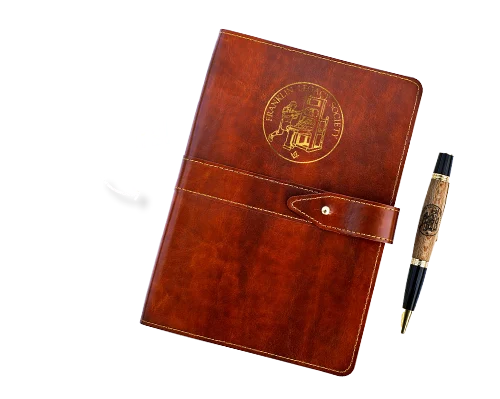 Brown journal and wooden pen with an arrow pointing to them and text, "Gift for members"
