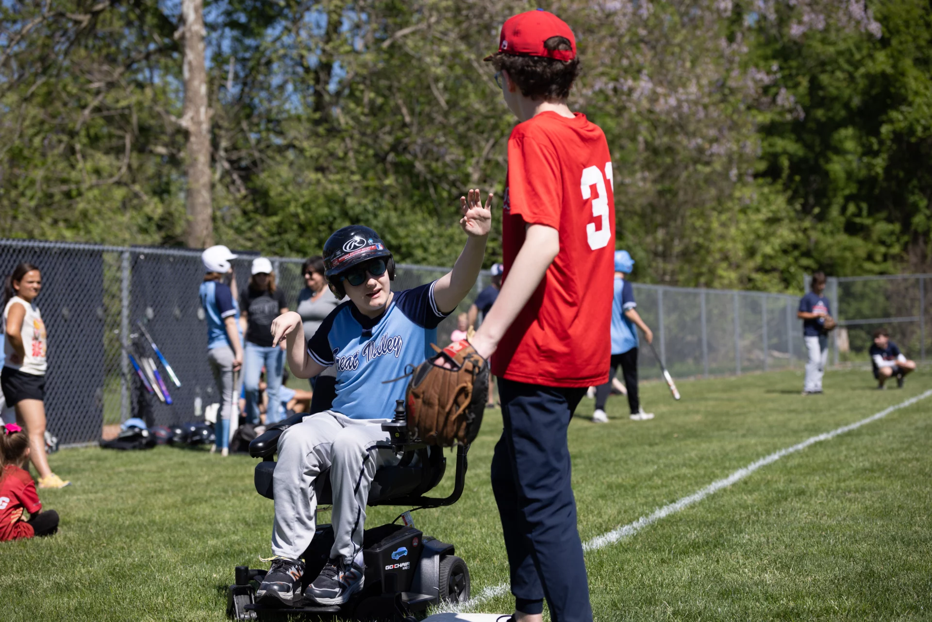 1E7A5121 Players high-fiving each other as they pass on a baseball field.
