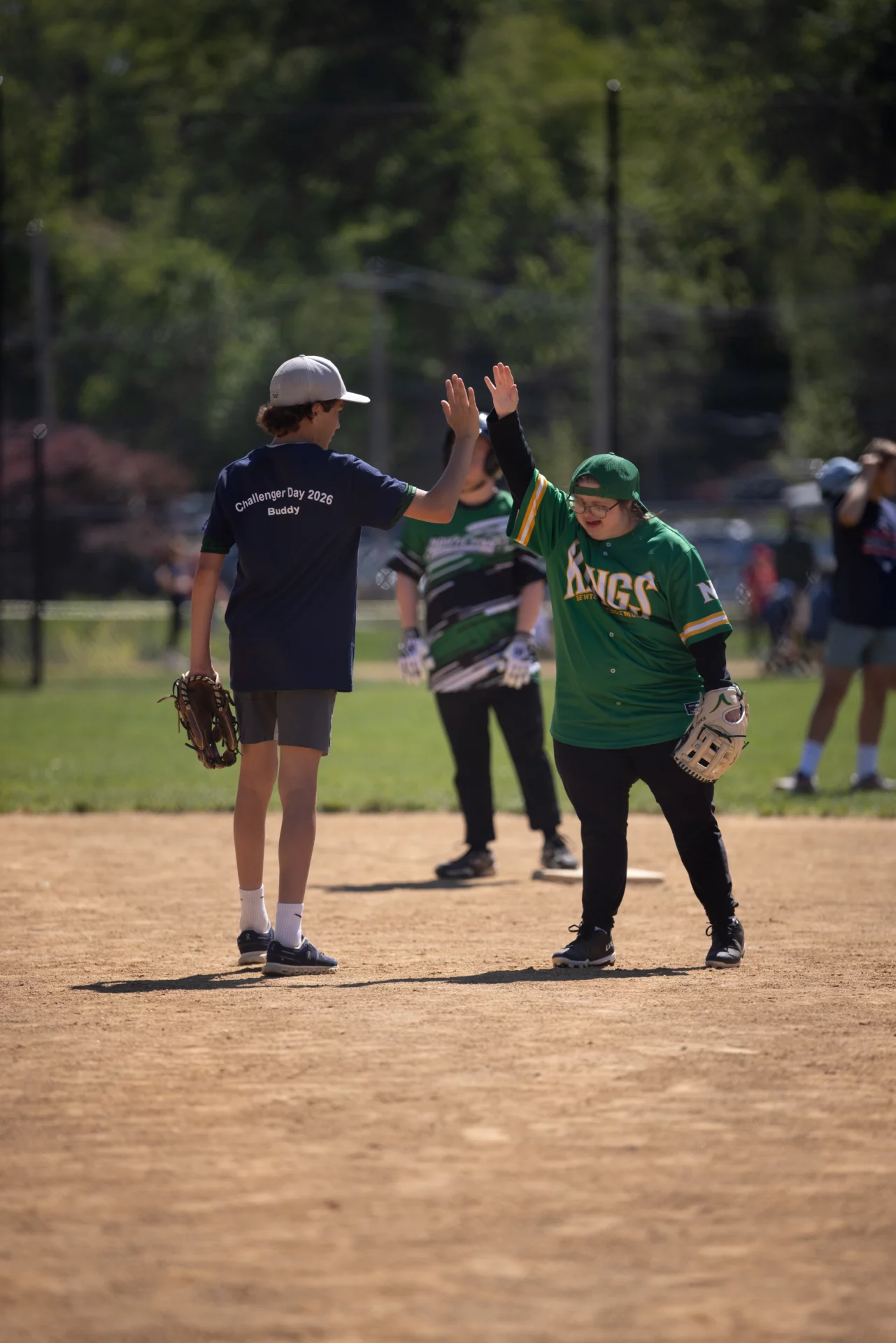 1E7A5160 Players high-fiving on a baseball field.