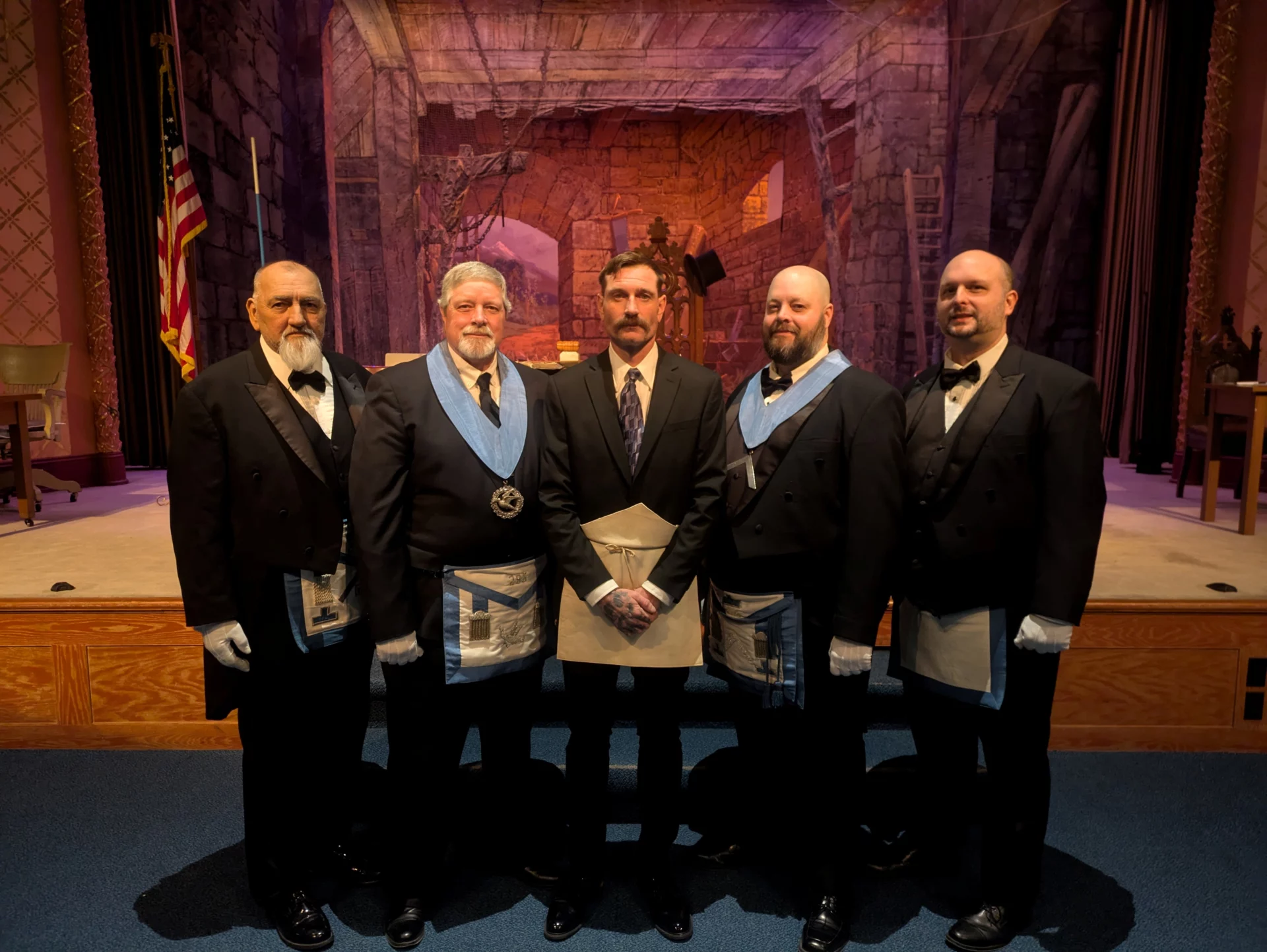 Smiling group of Masons standing indoors together.
