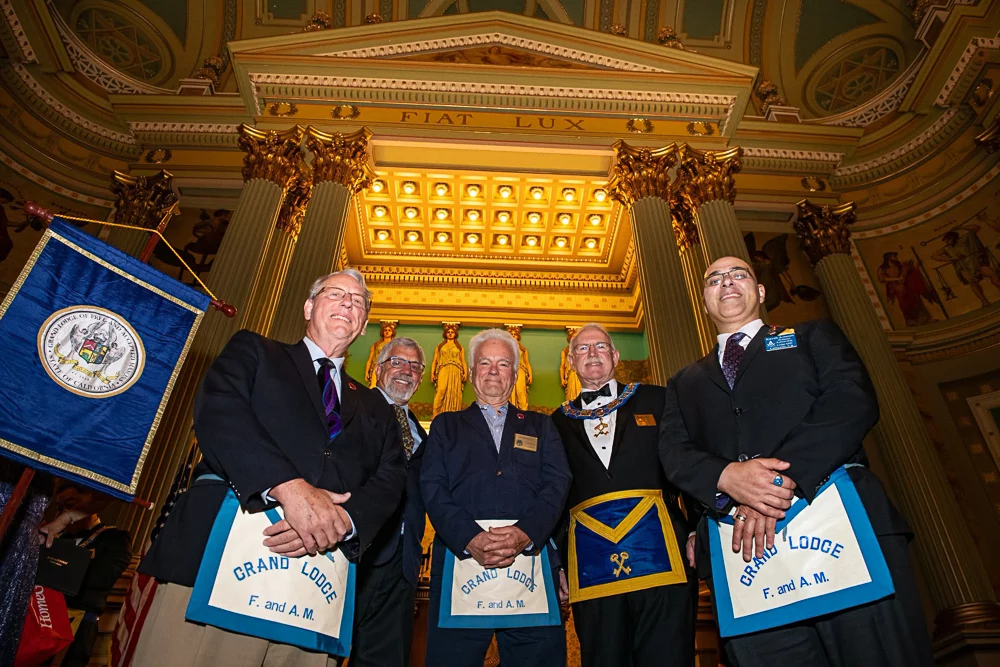742145118_2948040658877484_2073360492736765652_n Worms-eye view of smiling group of Masons standing in an ornate lodge room.