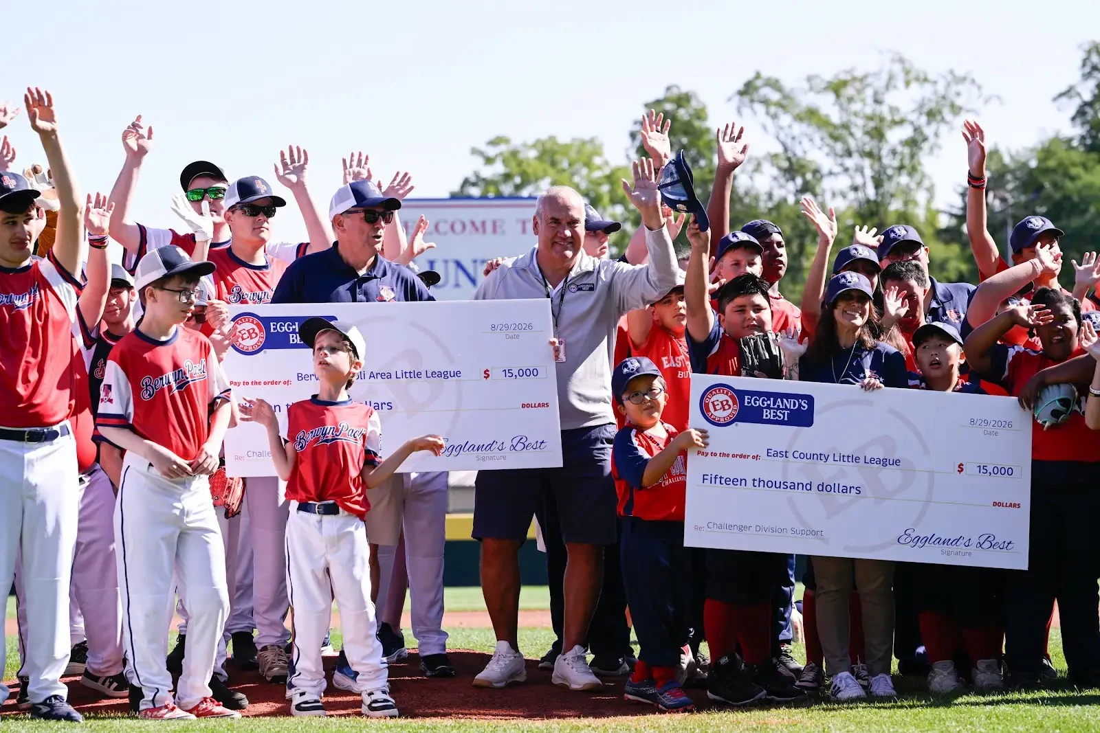 Eggland Smiling group of children and adults showing off giant checks.