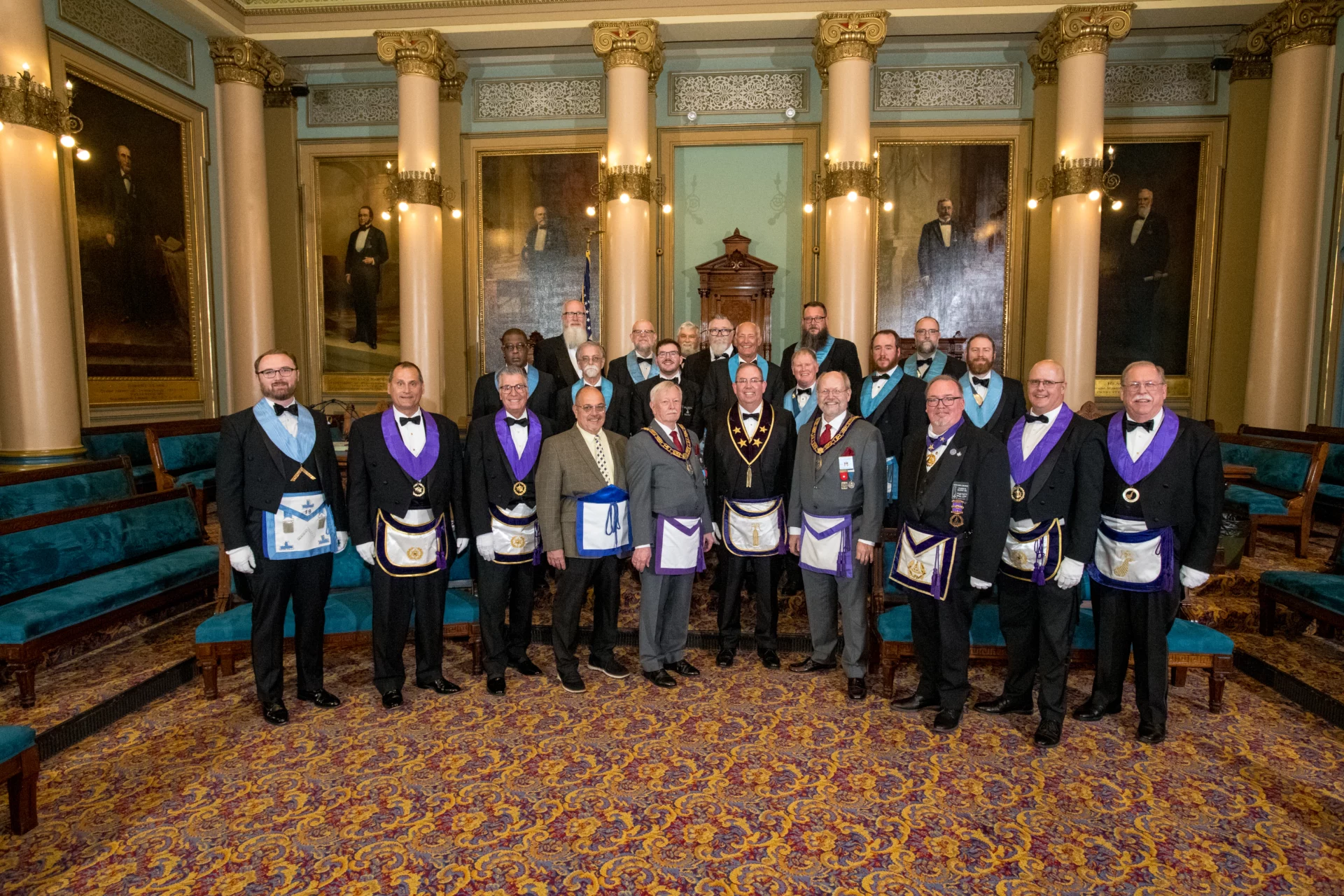 Smiling group of Masons standing together in a lodge room.